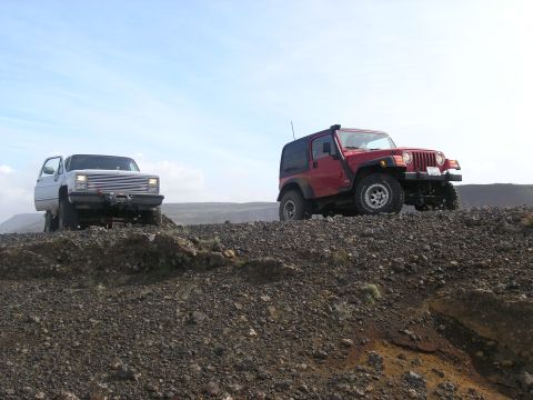 2001 Jeep Wrangler - Two off-road vehicles, a red Jeep TJ and a white pickup, navigate a rocky terrain.