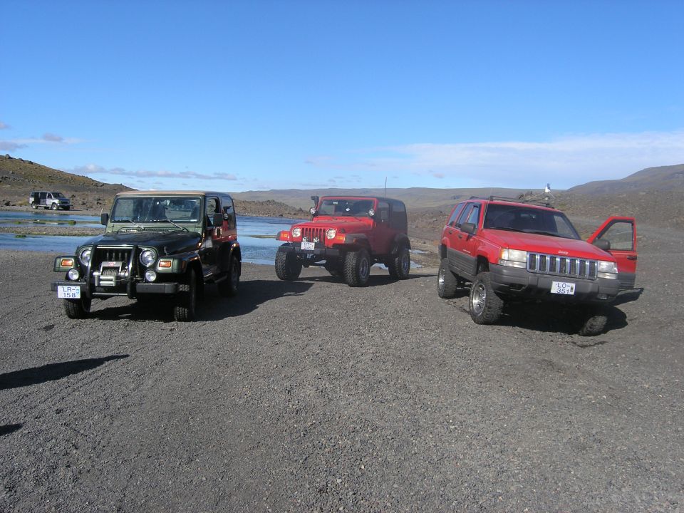 2001 Jeep TJ and two other Jeep SUVs parked near water