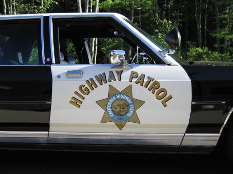 1991 Ford LTD Crown Victoria - Detail of a white door panel lettered HIGHWAY PATROL with a gold California Highway Patrol seven-point star emblem.