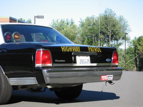 1991 Ford LTD Crown Victoria - Close rear view of a black Highway Patrol sedan showing the LTD Crown Victoria badge, Ford emblem, and California plate 281435.