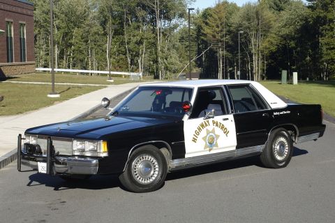 1991 Ford Crown Victoria - A 1991 Ford Crown Victoria police car is seen from a three-quarter front angle, displaying its official markings.