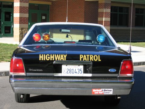 1991 Ford LTD Crown Victoria - Direct rear view of a black Highway Patrol LTD Crown Victoria sedan with red and blue roof beacons and California plate 281435.