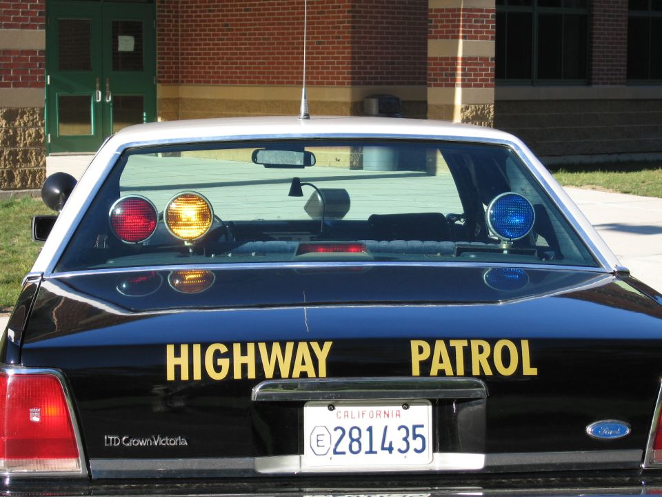 Rear of black Ford Crown Victoria police car, HIGHWAY PATROL, California plate 281435