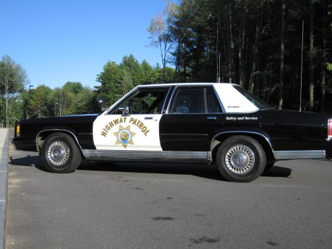 1991 Ford LTD Crown Victoria - Full driver-side profile of a black-and-white Ford patrol sedan with HIGHWAY PATROL lettering and a gold California Highway Patrol star on…