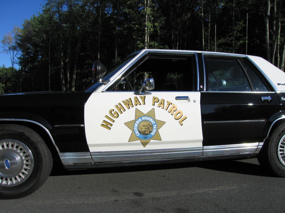 Close-up of patrol car door with HIGHWAY PATROL lettering and gold star badge