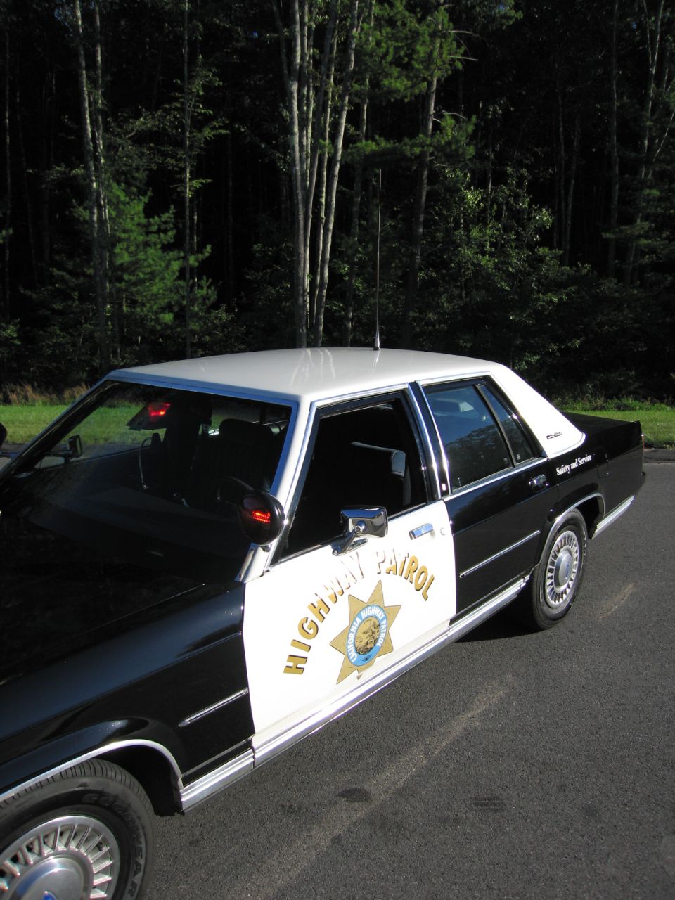 High-angle side view of black-and-white highway patrol sedan with star emblem