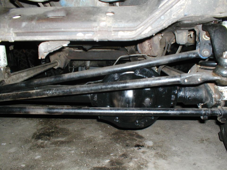 Undercarriage of a vehicle showing a black differential and steering linkage