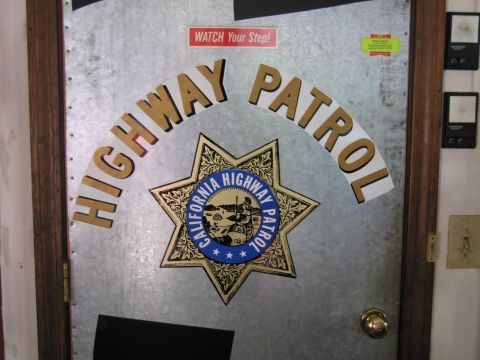 1991 Ford LTD Crown Victoria - galvanized metal door decorated with arched HIGHWAY PATROL lettering and a California Highway Patrol seven-point star emblem.