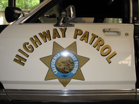 1991 Ford LTD Crown Victoria - White vehicle door painted with arched gold HIGHWAY PATROL lettering and a California Highway Patrol seven-point star emblem.