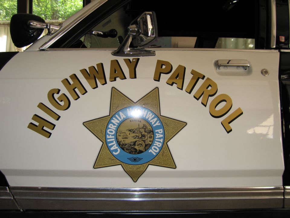 White car door with arched HIGHWAY PATROL lettering and CHP star emblem