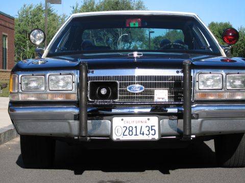1991 Ford LTD Crown Victoria - Front-on view of a Ford police sedan showing the chrome grille, black brush guard and a California plate reading 281435.
