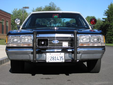 1991 Ford LTD Crown Victoria - Symmetrical head-on view of a dark blue Ford police sedan with chrome grille, push bar and California plate 281435.
