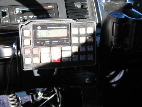 1991 Ford LTD Crown Victoria - Close-up of a GE Mobile Communications mobile radio control head with numeric keypad and digital display mounted on a vehicle console.