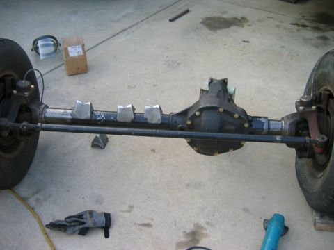1985 Ford Bronco - Vehicle axle assembly with welded brackets on the axle tube, ready for modification.
