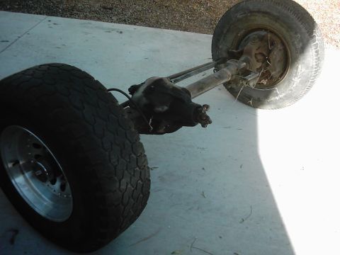 1978 Ford Bronco - A rear axle assembly with two tires is shown on a concrete surface, with a watermark from Supermotors.net visible.