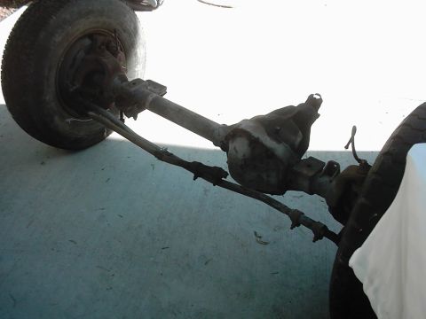 1978 Ford Bronco - Close-up view of a vehicle's front axle and steering components, including a tire.