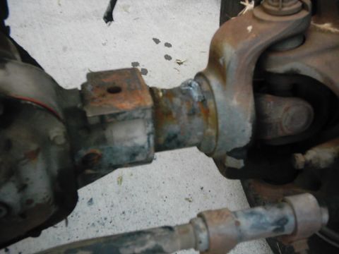 1978 Ford Bronco - Close-up view of heavily rusted vehicle axle and suspension parts. SuperMotors watermark visible.