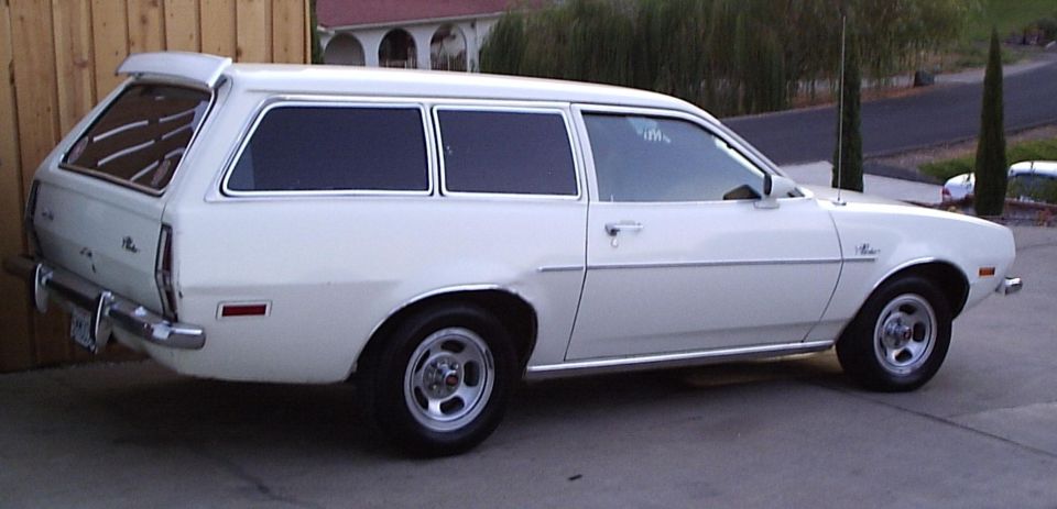 White Ford Pinto station wagon with woodgrain delete parked in a driveway