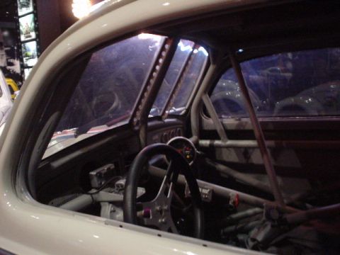 1968 Ford Mustang - The interior of a custom race car features a prominent roll cage and racing steering wheel.