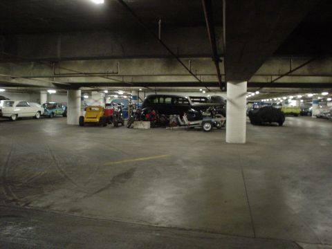 1968 Ford Mustang - A variety of vehicles are parked in a dimly lit parking garage.
