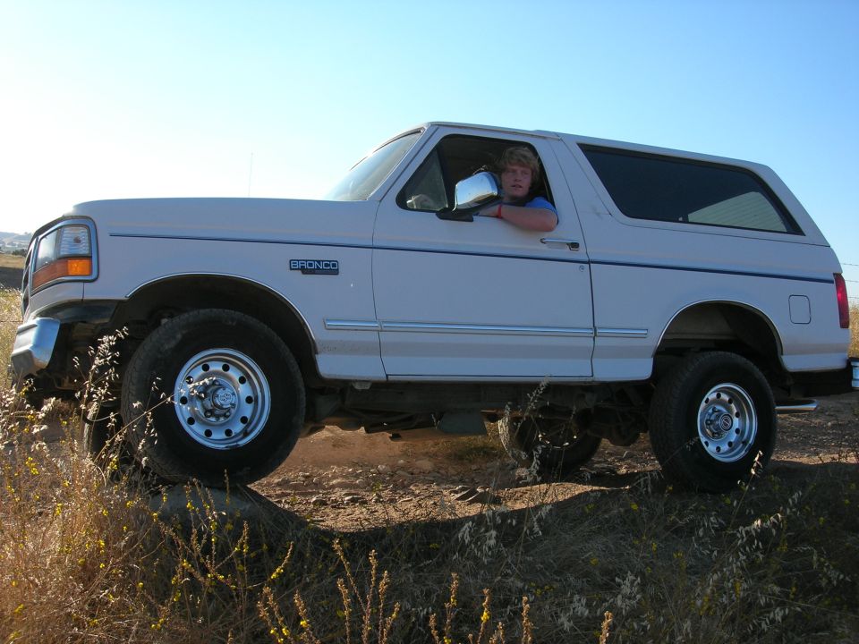White 1994 Ford Bronco side view with driver