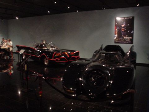 1968 Ford Mustang - A display of iconic movie vehicles, including the Batmobile, is presented in a museum setting.