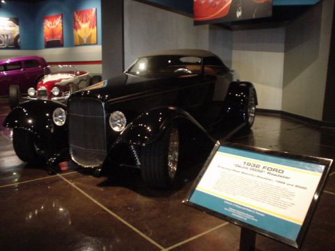 1968 Ford Mustang - A black 1932 Ford Roadster is displayed in a museum setting, with other vehicles visible in the background.