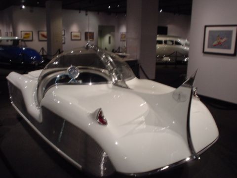 1968 Ford Mustang - A futuristic concept car with a distinctive bubble canopy and tail fins is on display in a museum setting.