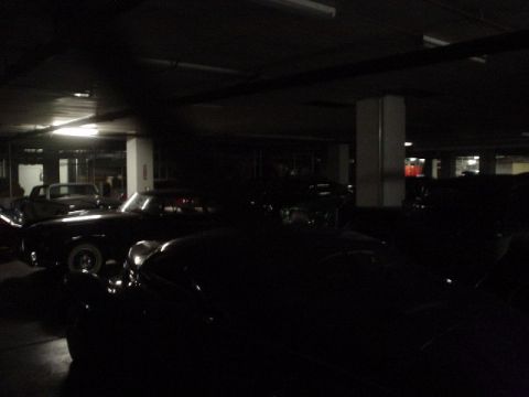 1968 Ford Mustang - A collection of classic automobiles are visible in a dimly lit indoor parking facility.