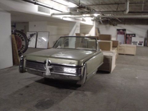 1968 Ford Mustang - A 1967 Chrysler Imperial convertible is parked in a warehouse, surrounded by crates and boxes.