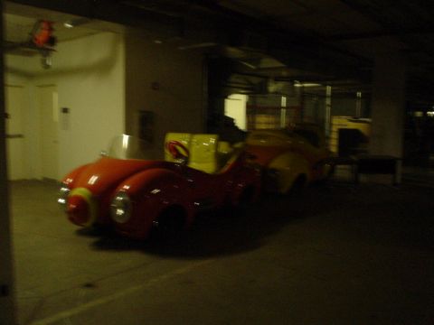 1968 Ford Mustang - Two whimsical, brightly colored cars are parked in a dimly lit indoor space.
