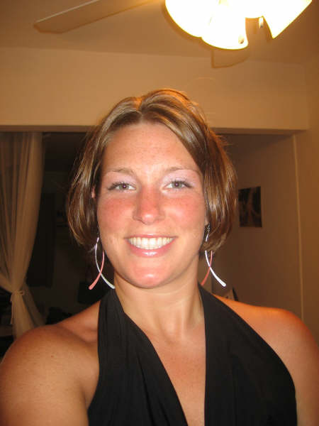 1991 Ford Bronco - Woman with freckles and short brown hair smiles, wearing a black dress and large earrings.