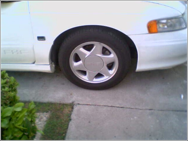 White 1993 Ford Taurus front wheel and fender, side view