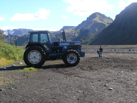 2001 Jeep Wrangler - A blue Ford tractor sits in a rocky, mountainous landscape under a clear sky.