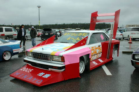 1991 Ford Bronco - Customized sedan with extreme body modifications and large rear wing, parked in a lot.