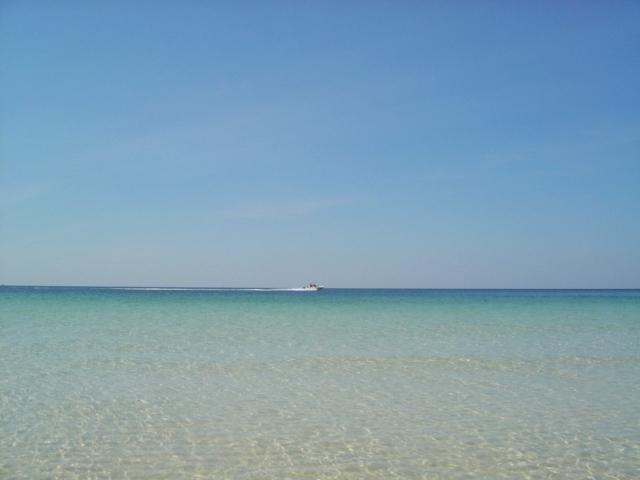 Boat on turquoise water under a clear blue sky