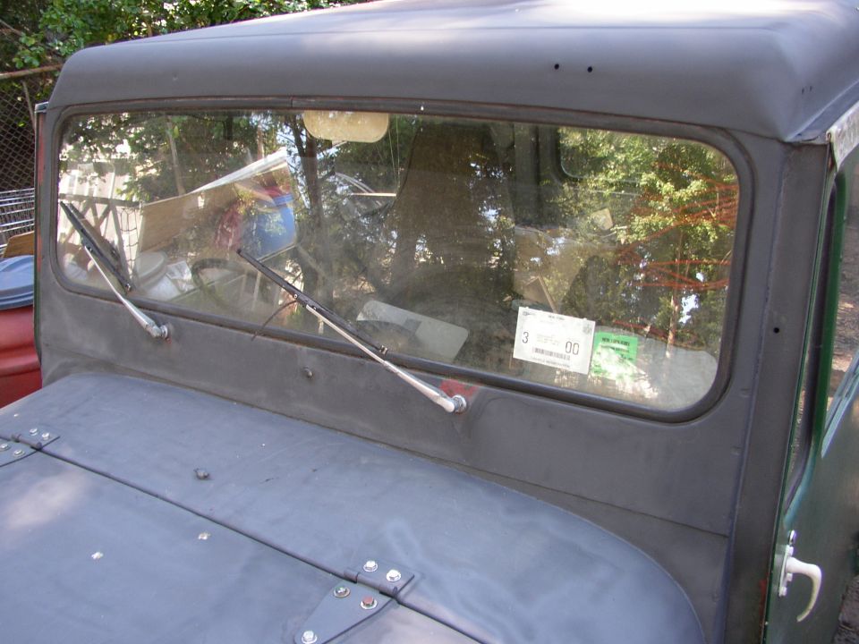 1973 Jeep CJ5 windshield with inspection sticker and wipers