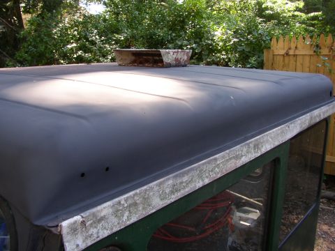 1973 Jeep CJ5 - The black hardtop of a 1973 Jeep CJ5 shows a metal scoop and weathered trim.