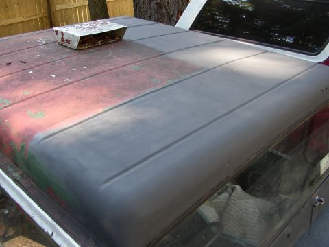 1973 Jeep CJ5 - The roof of a 1973 Jeep CJ5 shows a transition from faded red paint to primer, with a metal scoop attached.