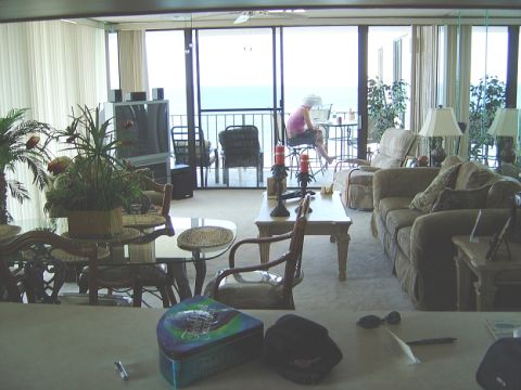 1986 Ford Bronco - Interior view of a living room with a person on the balcony and a view of the ocean.