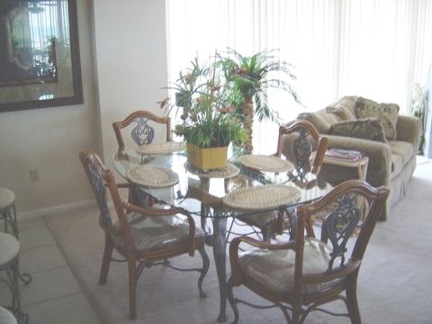 1986 Ford Bronco - A dining room scene with a glass table, chairs, sofa, and decorative plants. A watermark is visible in the lower right corner.