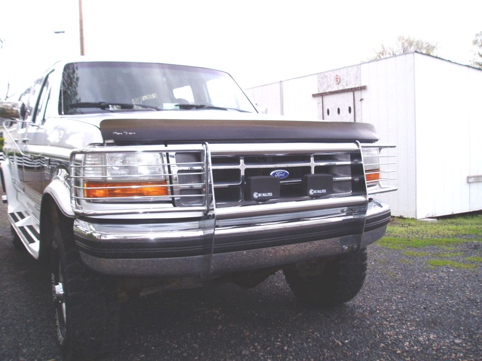 Front of lifted white Ford F-series truck with chrome brush guard and amber turn signals