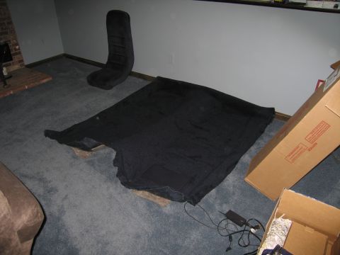 1991 Ford LTD Crown Victoria - black car headliner shell laid out on grey carpet in a room with a chair and open cardboard boxes nearby.