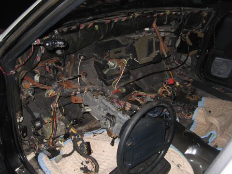 1991 Ford LTD Crown Victoria - Interior of a car with the dashboard removed, exposing tangled wiring, the steering column, and the bare firewall.