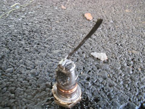 1992 Ford Bronco - This spark plug appears to be in poor condition, with a bent electrode and significant wear.