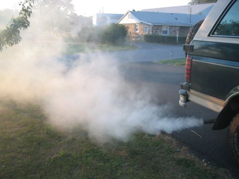 1992 Ford Bronco - A 1992 Ford Bronco is seen from the rear, emitting a large cloud of white smoke from its exhaust pipe.