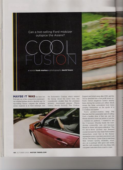 1998 Ford Taurus - A red sedan is shown from a 3/4 front angle as it drives on a curved road.