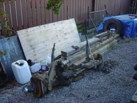 1986 Ford F-150 - A disassembled front axle assembly is shown outdoors, with lumber and other items in the background.
