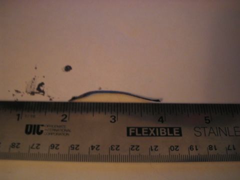 1992 Ford Bronco - A ruler is placed next to a small dent on a surface, showing its approximate size.