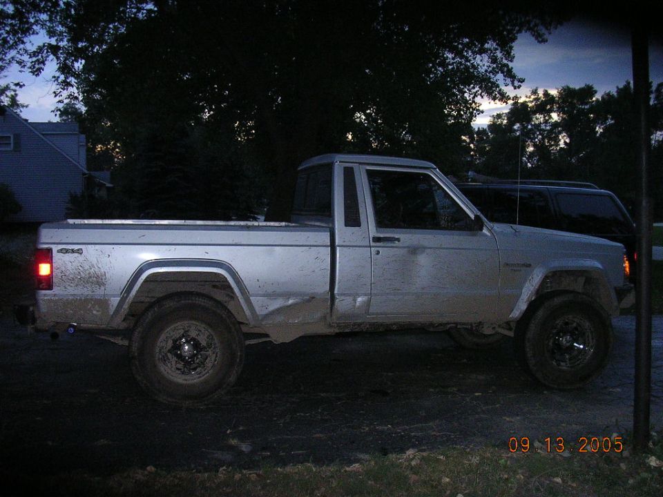 Silver Jeep Comanche pickup truck, side view, appears dirty